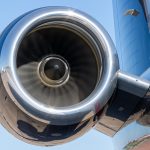 Rolls Royce aircraft engine in motion on a Gulfstream private jet set against a blue sky.